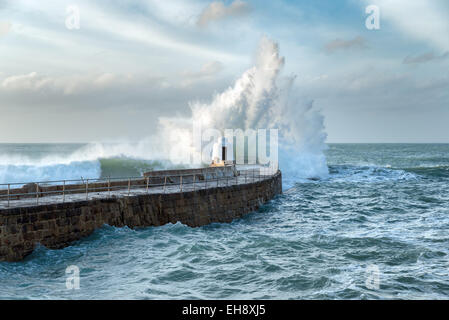 Huge waves crashing over the Monkey Hut on the stone pier at Portreath on the Cornwall coast Stock Photo