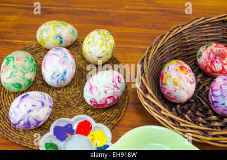 Freshly painted Easter eggs in a basket on a wooden table Stock Photo