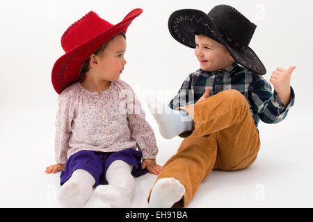 two brothers smiling wearing cowboy hats Stock Photo