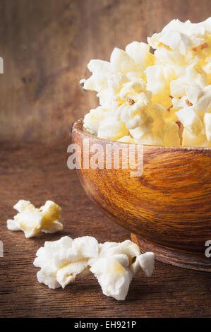 Fresh popcorn in bowl on wooden table