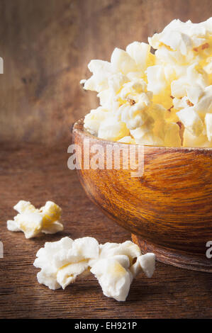 Fresh popcorn in bowl on wooden table Stock Photo