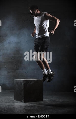 Athlete gave exercise. Jumping on the box. Phase touchdown. Stud Stock Photo
