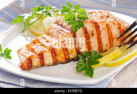 Grilled Salmon with lemon and  fresh herbs . Selective focus Stock Photo