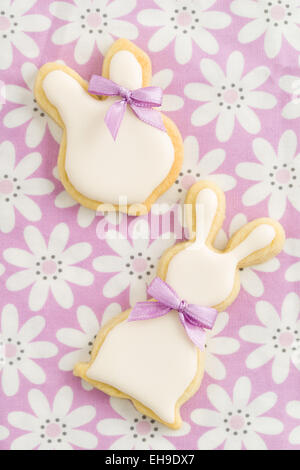 Easter bunny sugar cookies with cute ribbon bows on pink chequered tablecloth Stock Photo