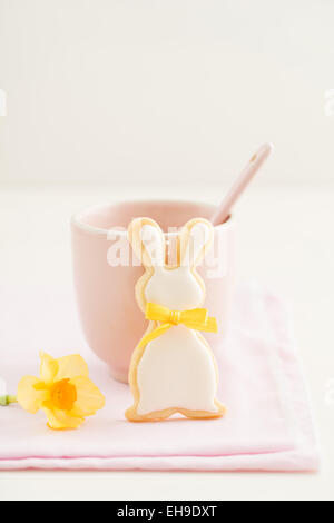 Easter bunny sugar cookie with bow tie and a pink cup Stock Photo