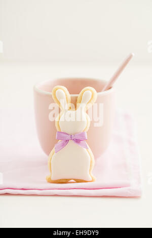 Easter bunny sugar cookie with bow tie and a pink cup Stock Photo