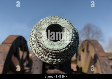 looking down the barrel Weathered patina on Light British copper bronze field cannon gun with fine decoration and molding Stock Photo