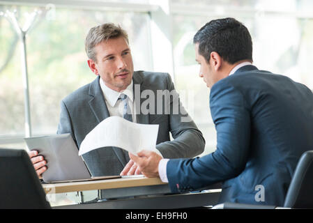 Businessmen negotiating in meeting Stock Photo