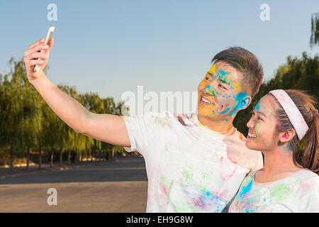 Couple taking selfie at The Color Run Stock Photo - Alamy
