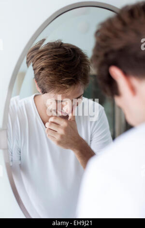 Man laughing to self, reflection in mirror Stock Photo