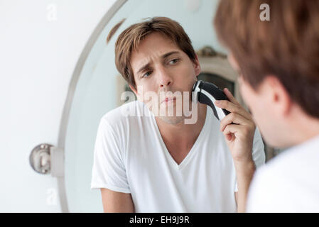 Man shaving with electric razor Stock Photo