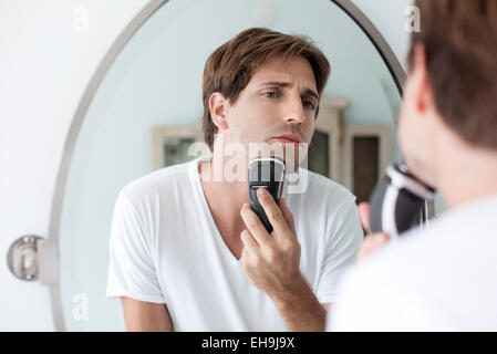 Man shaving with electric razor Stock Photo