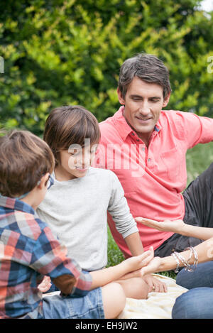 Boys playing hand game with family Stock Photo
