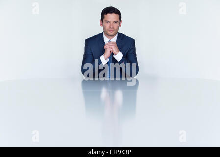 Confident businessman seated at table, portrait Stock Photo
