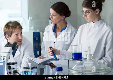 Scientists conducting experiment in laboratory Stock Photo