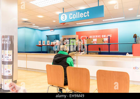 A customer waiting at the collection point inside an Argos store. Stock Photo