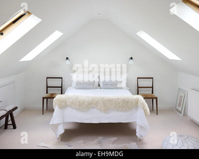 Bed and two chairs in white attic bedroom, residential house, Port Hall Street, Brighton, East Sussex, UK Stock Photo