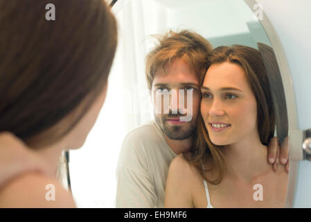 Couple looking in bathroom mirror together Stock Photo