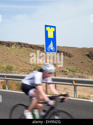 Cyclist passing sign on mountain road on Gran Canaria indicating obligatory use of high visibility jacket.