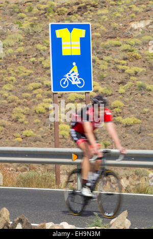 Cyclist passing sign on mountain road on Gran Canaria indicating obligatory use of high visibility jacket