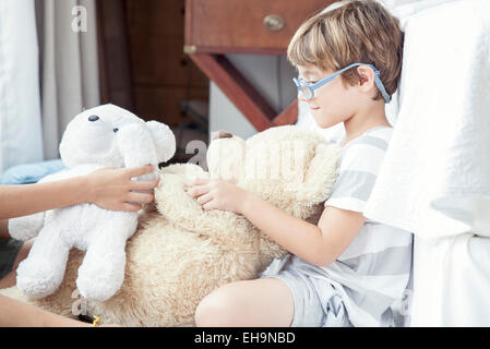 Little boy playing with teddy bear Stock Photo