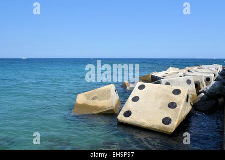 Coastline with concrete wave breaker in the shape of dice Stock Photo