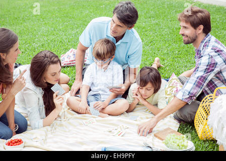 Family playing card game at picnic Stock Photo