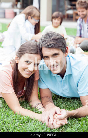 Couple lying side by side holding hands, portrait Stock Photo