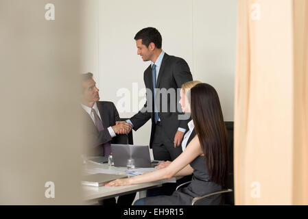 Executives meeting in conference room, viewed through doorway Stock Photo