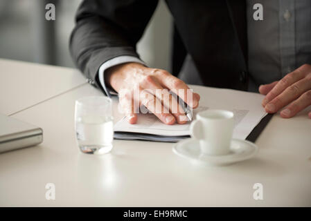 Businessman reviewing document, cropped Stock Photo