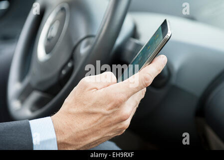Using smartphone while driving Stock Photo