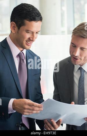 Business associates discussing document together Stock Photo