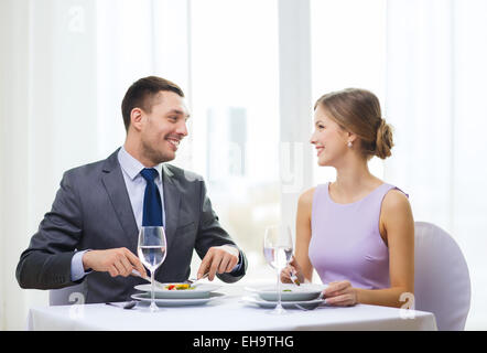 smiling couple eating appetizers at restaurant Stock Photo