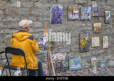 Outdoor artist painting and selling paintings on Pikk Jelg street in Old Town of Tallinn, Estonia Stock Photo