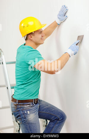 smiling man in helmet doing renovations at home Stock Photo