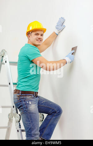 smiling man in helmet doing renovations at home Stock Photo
