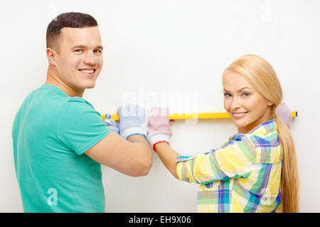 couple building using spirit level to measure Stock Photo