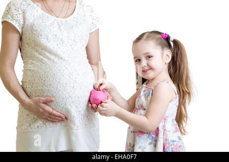 Pregnant mother and child putting coins into piggy bank Stock Photo