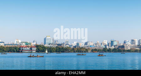 Hangzhou, China - December 5, 2014: The coast of West Lake, panorama with ordinary people in floating boats, Hangzhou city, Chin Stock Photo