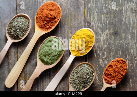 Different kinds of spices in spoons on wooden background Stock Photo Different kinds of spices in spoons on wooden background Stock Photo