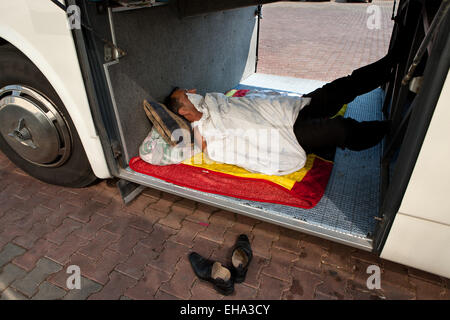 Turkish man taking a nap in the luggage compartment at the bus Stock Photo