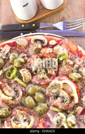 Delicious italian pizzas served on wooden table Stock Photo