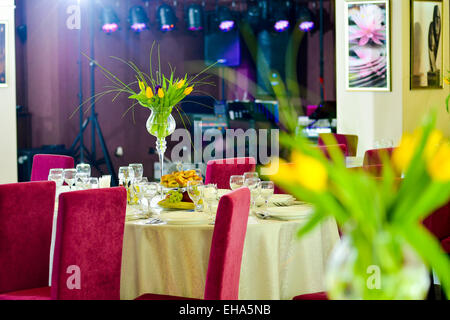 Restaurant dining table with yellow tulips Stock Photo