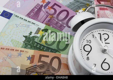 Euro notes and a clock. Time is money. (50, 100 and 500 EUR)