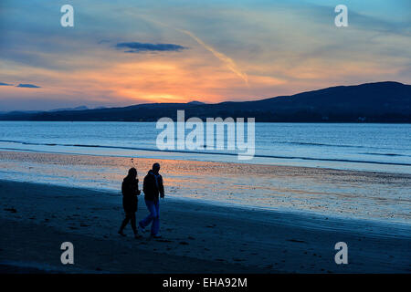 Donegal, Ireland. 10th March, 2015. Weather: A couple walk along the beach at Lisfannon, County Donegal, as the sun sets. Widespread showers are forecast for Donegal on Wednesday Credit:  George Sweeney/Alamy Live News Stock Photo