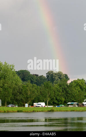 The end of the rainbow touches down at a campsite along the Saône River in Burgundy, France. Stock Photo