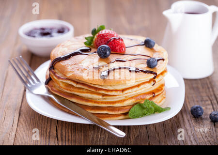 Delicious sweet American pancakes on a plate with fresh fruits and addons. Stock Photo