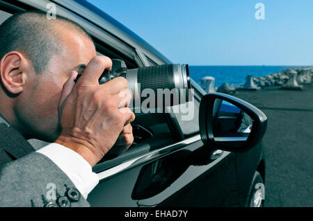 a detective or a paparazzi taking photos from inside a car Stock Photo