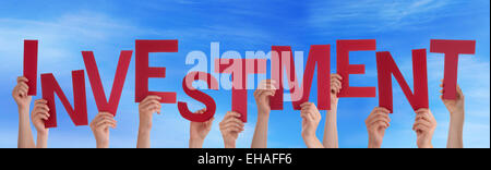 Many Caucasian People And Hands Holding Red Letters Or Characters Building The English Word Investment On Blue Sky Stock Photo