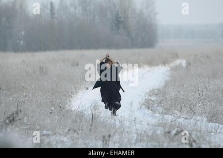 running samurai wearing a kimono in a winter field dressed in black, frost Stock Photo